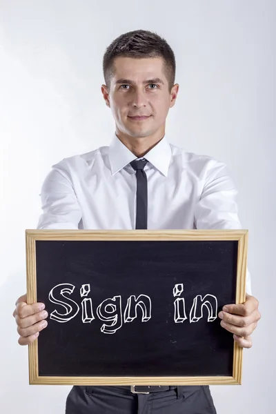 Iniciar sesión - Young businessman holding chalkboard — Foto de Stock