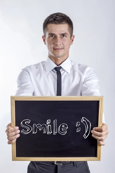 Sorriso:) - Jovem empresário segurando quadro — Fotografia de Stock