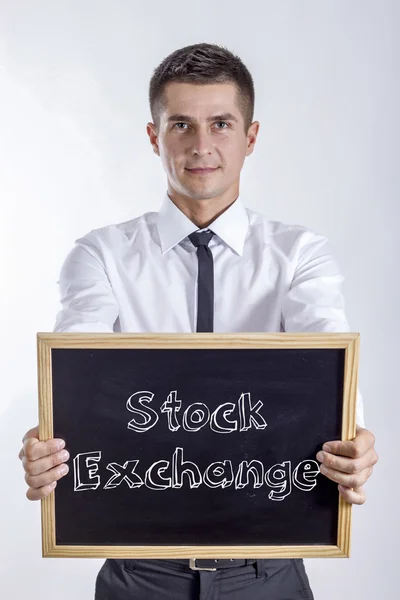 証券取引所 - 黒板を保持している青年実業家 — ストック写真