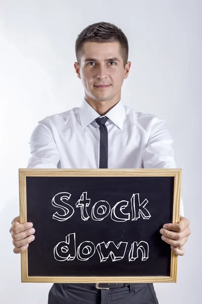 Stock down - Jovem empresário segurando quadro — Fotografia de Stock