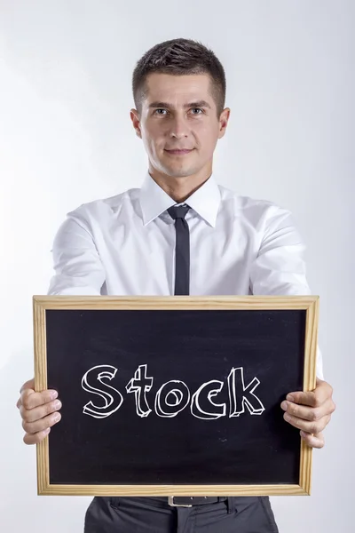 Акции - Молодой бизнесмен держит доску — стоковое фото