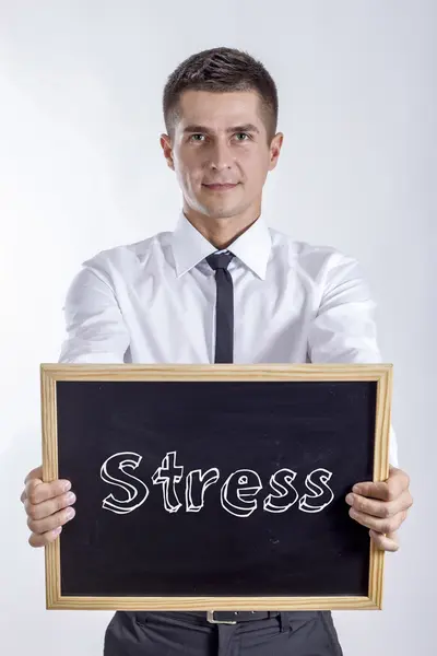 Stress - ung affärsman holding svarta tavlan — Stockfoto