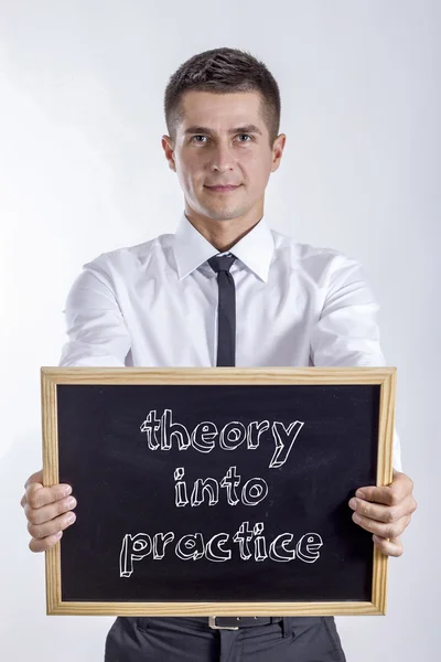 Theorie in de praktijk - jonge zakenman houden schoolbord — Stockfoto