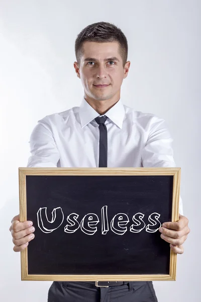 Useless - mladý podnikatel drží tabuli — Stock fotografie