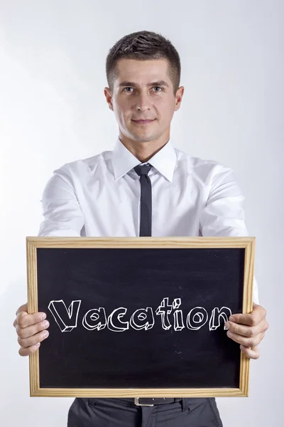 Vacation - Young businessman holding chalkboard — Stock Photo, Image