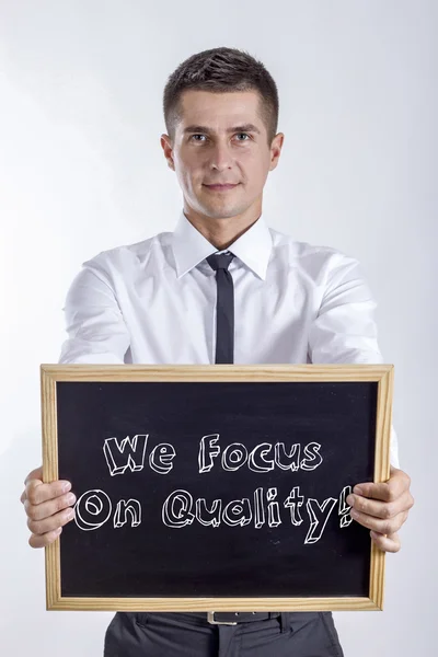 Nós nos concentramos na qualidade! - Jovem empresário segurando quadro — Fotografia de Stock