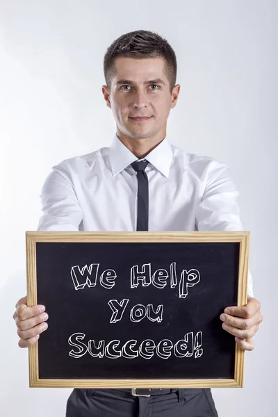 ¡Le ayudamos a tener éxito! - Joven hombre de negocios sosteniendo pizarra — Foto de Stock