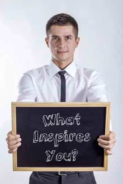 Wat inspireert jou? -Jonge zakenman bedrijf schoolbord — Stockfoto