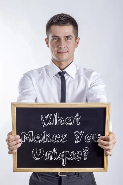 Mitől egyedi? -Fiatal üzletember gazdaság chalkboard — Stock Fotó
