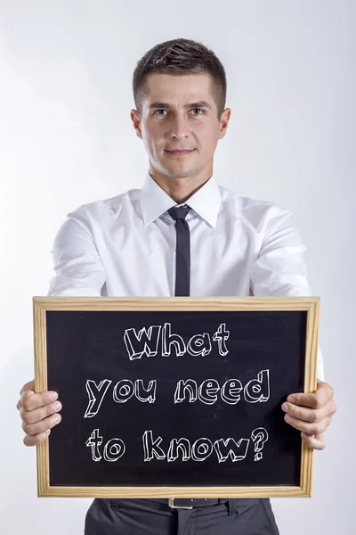Mit kell tudni? -Fiatal üzletember gazdaság chalkboard — Stock Fotó