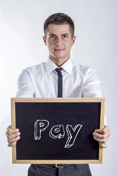 Lön - ung affärsman holding svarta tavlan — Stockfoto