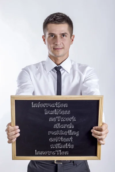 Information BusiNess NeTwork SEarch MaRketing CoNtent WEbsite in - Young businessman holding chalkboard — Stock Photo, Image