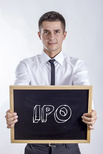 IPO - Молодой бизнесмен держит доску с текстом — стоковое фото