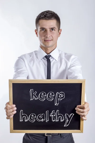 Gesund bleiben - Jungunternehmer hält Tafel mit Text in der Hand — Stockfoto