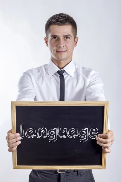 Taal - jonge zakenman houden schoolbord met tekst — Stockfoto