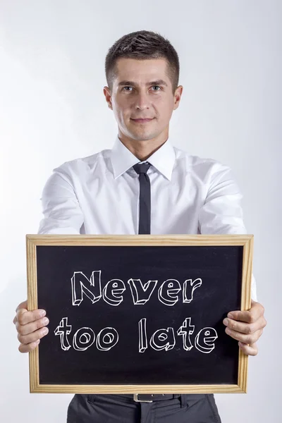 Never too late - Young businessman holding chalkboard with text — Stock Photo, Image