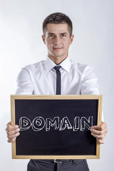 DOMAIN - молодий бізнесмен тримає клавіатуру з текстом — стокове фото