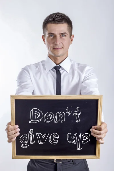 Nicht aufgeben - junger Geschäftsmann hält Tafel mit Text in der Hand — Stockfoto