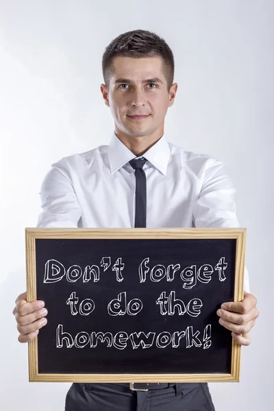 Nezapomeňte si udělat domácí úkoly! -Mladý podnikatel drží tabule s textem — Stock fotografie