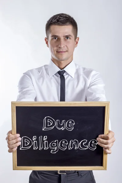 Due Diligence - Joven hombre de negocios sosteniendo pizarra — Foto de Stock