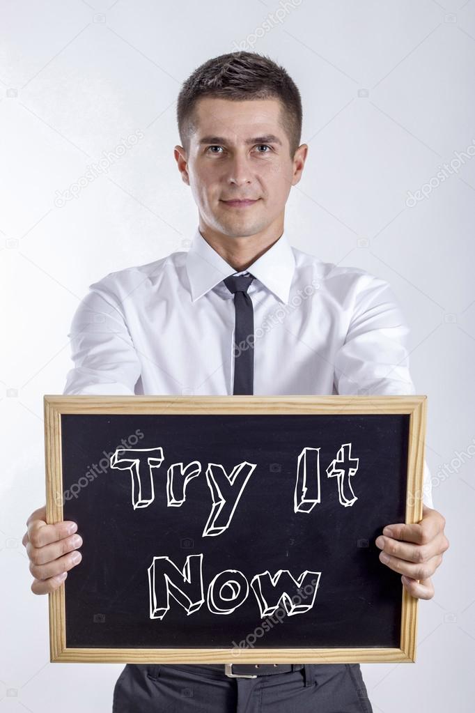 Try It Now - Young businessman holding chalkboard