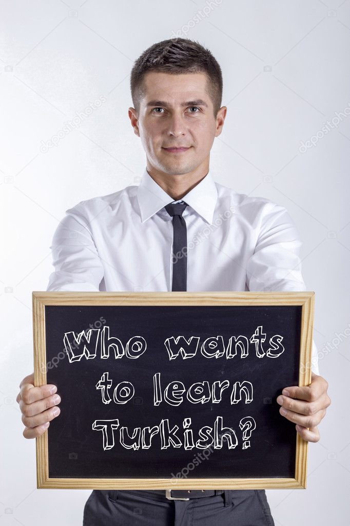 Who wants to learn Turkish? - Young businessman holding chalkboard