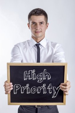 Yüksek öncelikli - kara tahta tutan genç işadamı