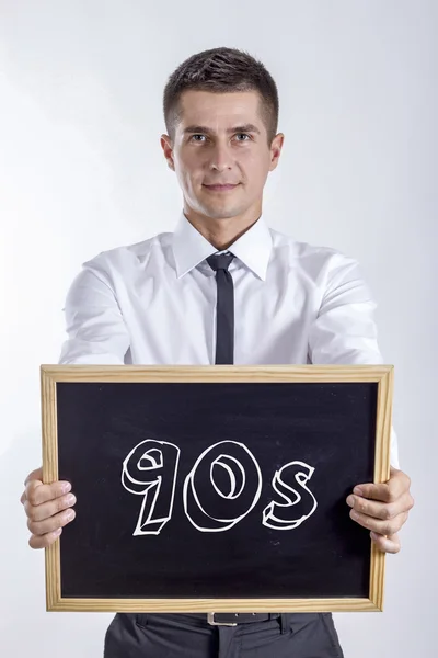 90s - Joven empresario sosteniendo pizarra con texto — Foto de Stock