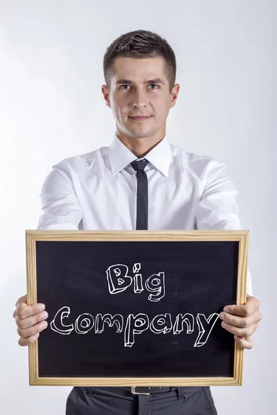 Big Company - Young businessman holding chalkboard with text — Stock Photo, Image