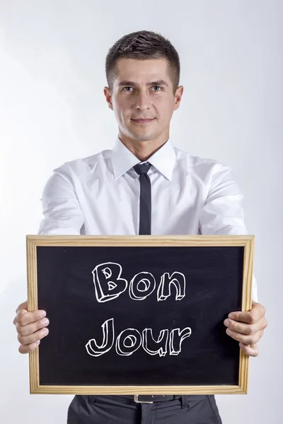 Bon Jour - ung affärsman holding svarta tavlan med text — Stockfoto