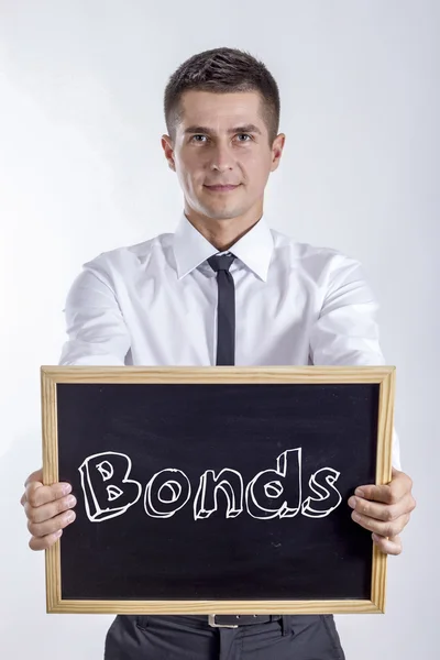 Obligacje - młody biznesmen posiadania tablica z tekstem — Zdjęcie stockowe