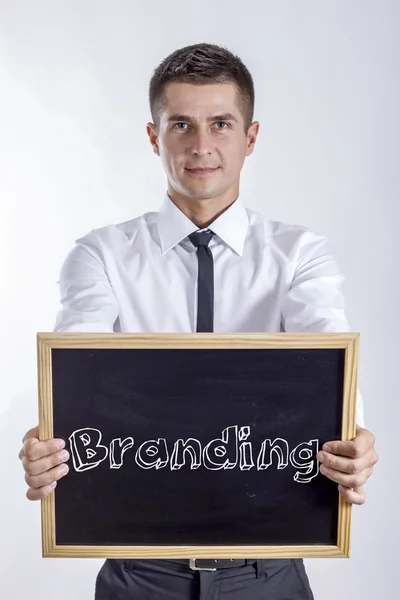 Branding - Young businessman holding chalkboard with text — Stock Photo, Image