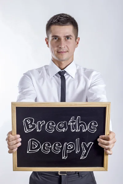 Andas djupt - ung affärsman holding svarta tavlan med text — Stockfoto