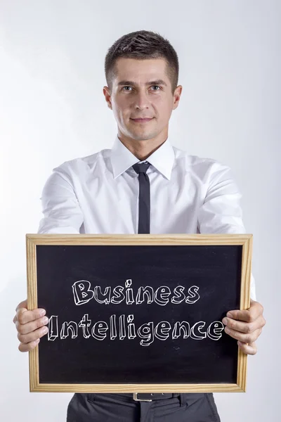 Business Intelligence - ung affärsman holding svarta tavlan med text — Stockfoto