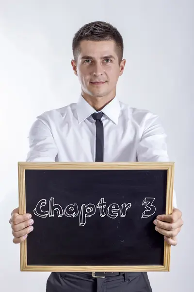 Capítulo 3 - Jovem empresário segurando quadro com texto — Fotografia de Stock