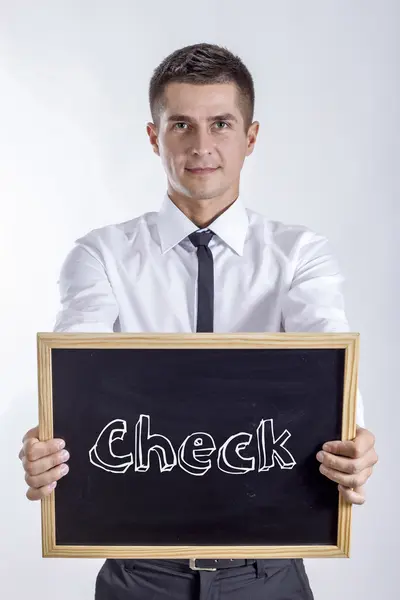 Check - Giovane imprenditore in possesso di lavagna con testo — Foto Stock
