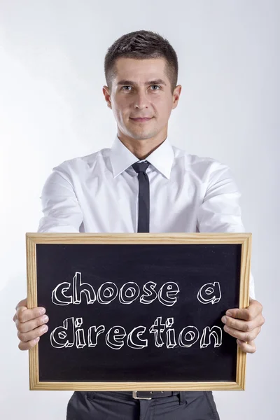 Choose a direction - Young businessman holding chalkboard with text — Stock Photo, Image
