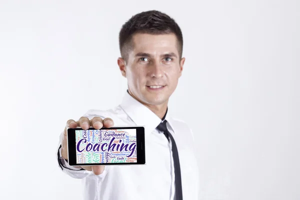 Coaching - giovane imprenditore in possesso di un telefono cellulare — Foto Stock