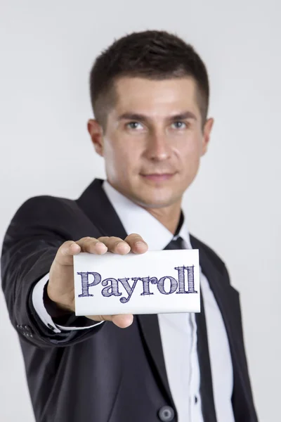 Folha de pagamento - Jovem empresário segurando um cartão branco com texto — Fotografia de Stock
