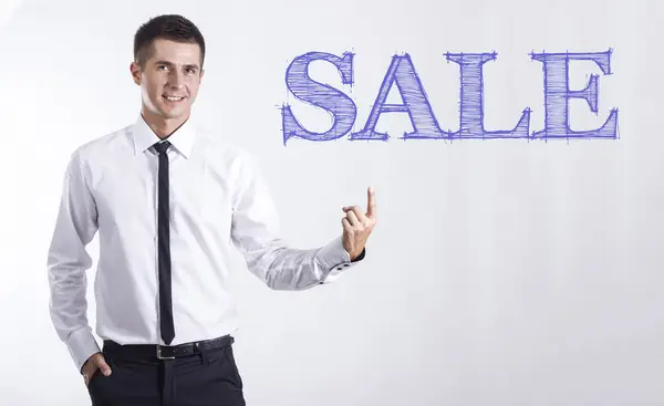 Πώληση - νεαρός χαμογελαστό επιχειρηματίας στραμμένο στο κείμενο — Φωτογραφία Αρχείου