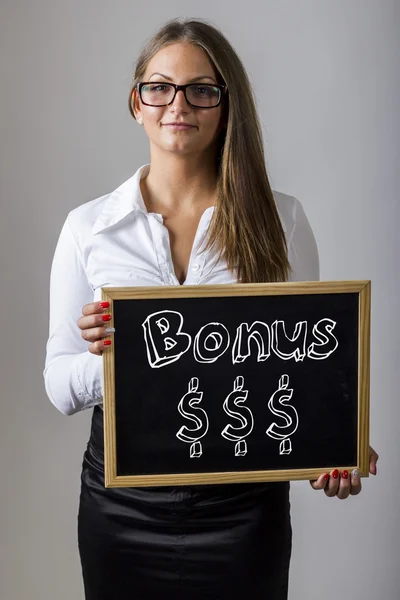 Bonus $$$ - Young businesswoman holding chalkboard with text — Zdjęcie stockowe