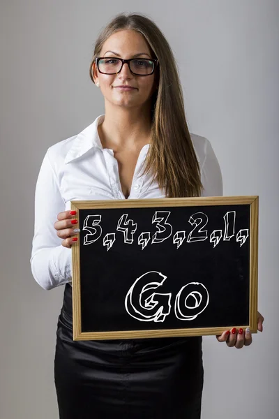 5,4,3,2,1, Go - Young businesswoman holding chalkboard with text — Stock Photo, Image