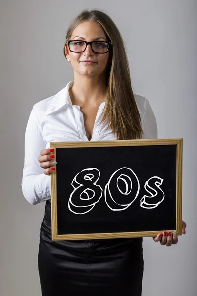80-е годы - молодая предпринимательница держит доску с текстом — стоковое фото