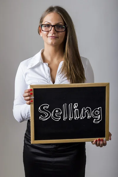 Selling - Young businesswoman holding chalkboard with text — 图库照片