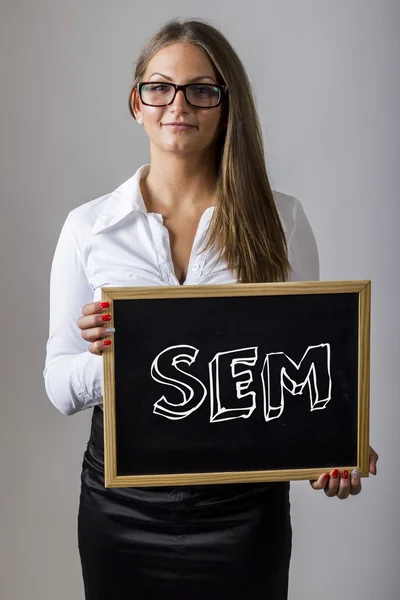 SEM - Young businesswoman holding chalkboard with text — Zdjęcie stockowe
