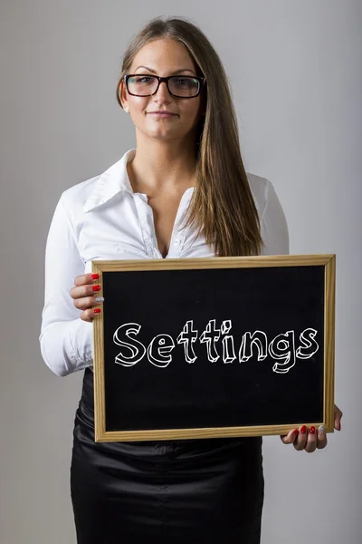 Settings - Young businesswoman holding chalkboard with text — Stock fotografie