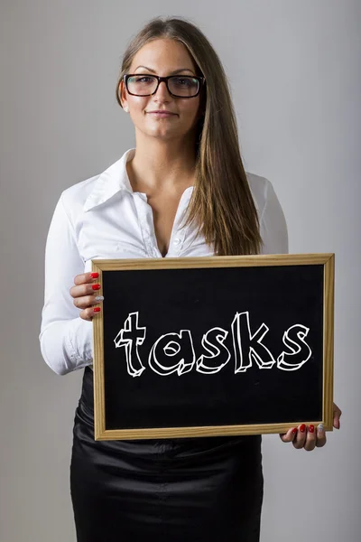 Tasks - Young businesswoman holding chalkboard with text — Φωτογραφία Αρχείου