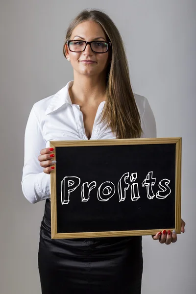 Profits - Young businesswoman holding chalkboard with text — Zdjęcie stockowe