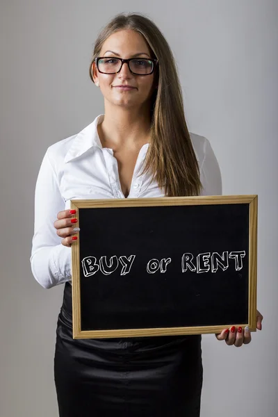 BUY or RENT  - Young businesswoman holding chalkboard with text — Stockfoto