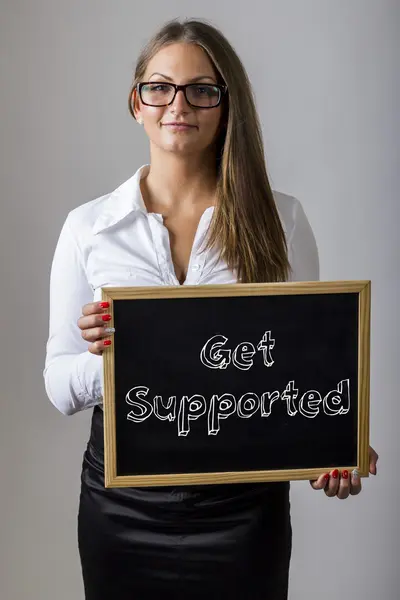 Get Supported - Young businesswoman holding chalkboard with text — Zdjęcie stockowe